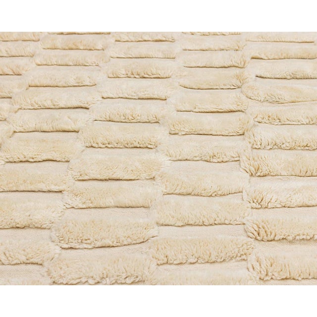 Luxurious hand-knotted wool rug with a textured flat woven checkered pattern in a warm Ivory palette, a timeless design...