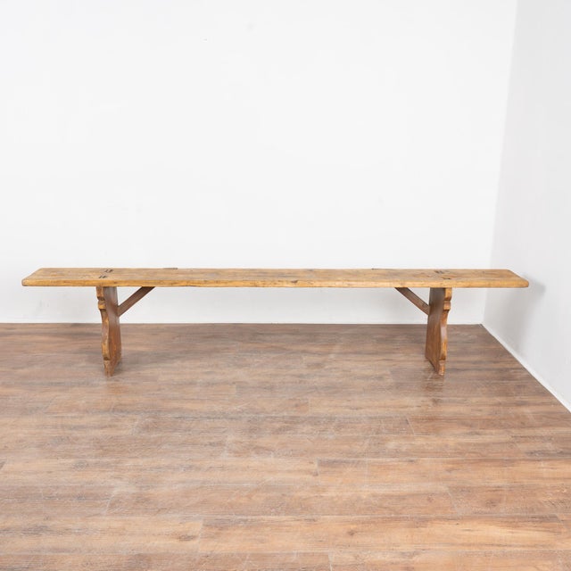 Rustic plank top pine bench with aged patina, just over 8' long. Residual old reddish-brown paint still evident on legs....