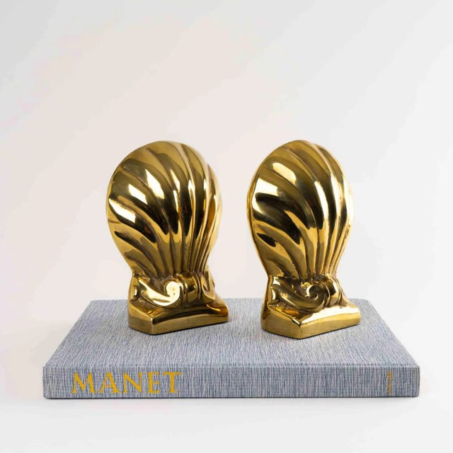 Elegant vintage brass bookends featuring a shell and scroll design. These heavy, substantial bookends showcase exquisite...