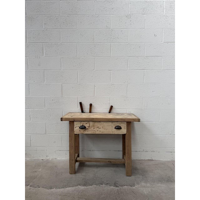 This antique cutting table made of unfinished beech wood has been fully restored. It features a tabletop with a knife slot...