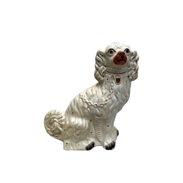 This pair of figurines are Staffordshire spaniel dogs, a classic English pottery design often used as "mantel dogs" to...