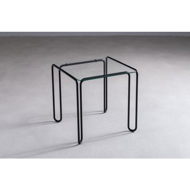 This vintage side table embodies the essence of minimalistic modernist design. Its structure is defined by a bent...
