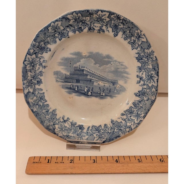 Ceramic plate with no maker's mark on reverse. The Crystal Palace is pictured in blue with a blue floral border. Blaze...