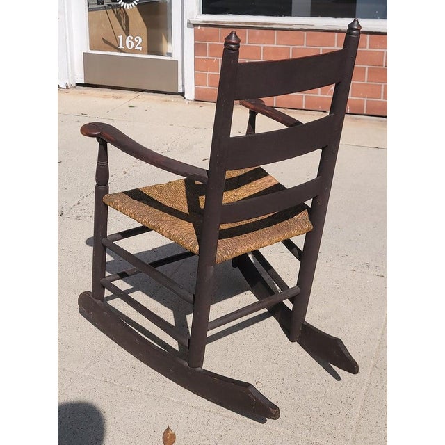 19Thc Original brown painted ladder back rocking chair from New England.This rocking chair has the original rush seat.The...