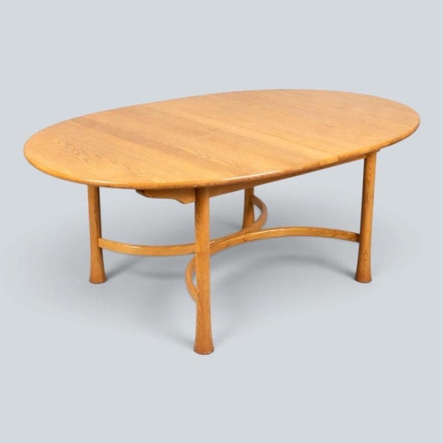 An original Ercol Saville oval dining table, showcasing the beautifully figured solid blonde elm top that has made Ercol...