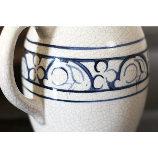 A white and blue ceramic pitcher made by The Potting Shed in the style of Dedham ceramics. Large creamer size in off white...