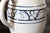 A white and blue ceramic pitcher made by The Potting Shed in the style of Dedham ceramics. Large creamer size in off white...