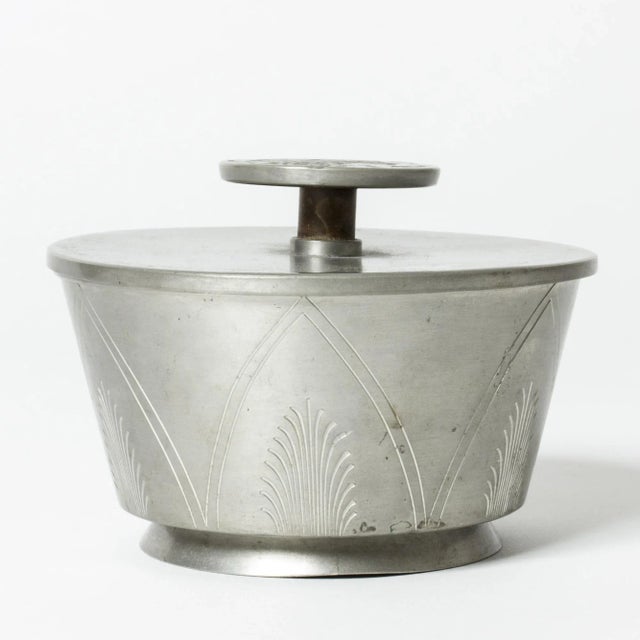 Pewter jar from Oscar Antonsson, in a beautiful design. Elevated knob on the lid, with a relief decor of a woman’s...