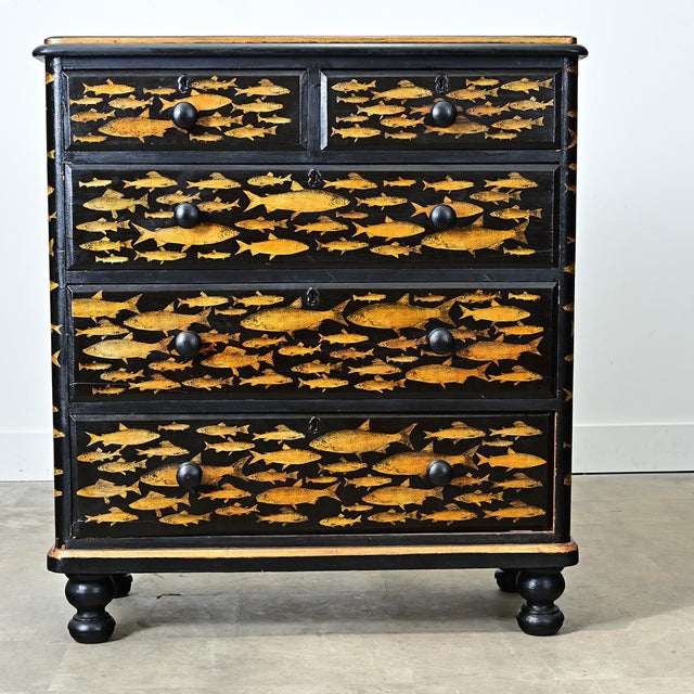 A 19th-century English pine chest recently updated with new paint of ebonized effect and pasted decoupage fish. The...
