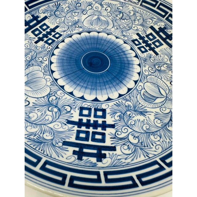 This is a beautiful large porcelain charger plate with a classic blue and white design, showcasing East Asian influence...