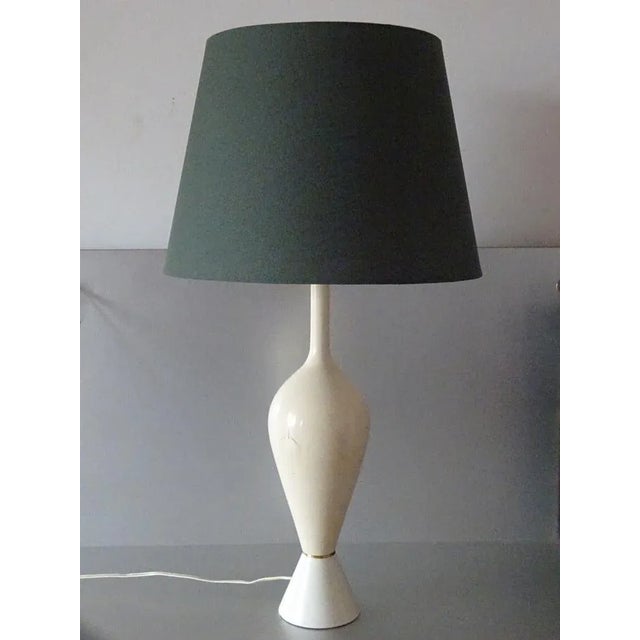 A pair of lamps of stylized, classical shapes, made of lacquered metal. New green-coloured shades. Good overall condition;...