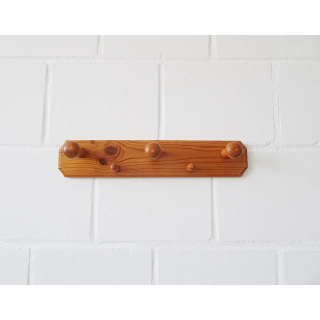 This coat bar made of solid pine wood is a wooden wardrobe from the 1970s. The spacious wardrobe offers three large and...