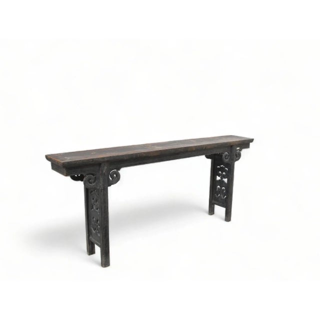 Crafted in the late 19th century, this altar table is distinguished by its intricately hand-carved double ruyi panel legs....