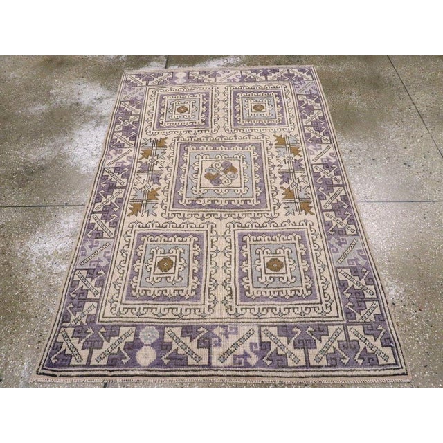 A vintage Turkish Anatolian throw rug. This pale straw ground scatter has a 2/1/2 pattern of hooked, nested square...