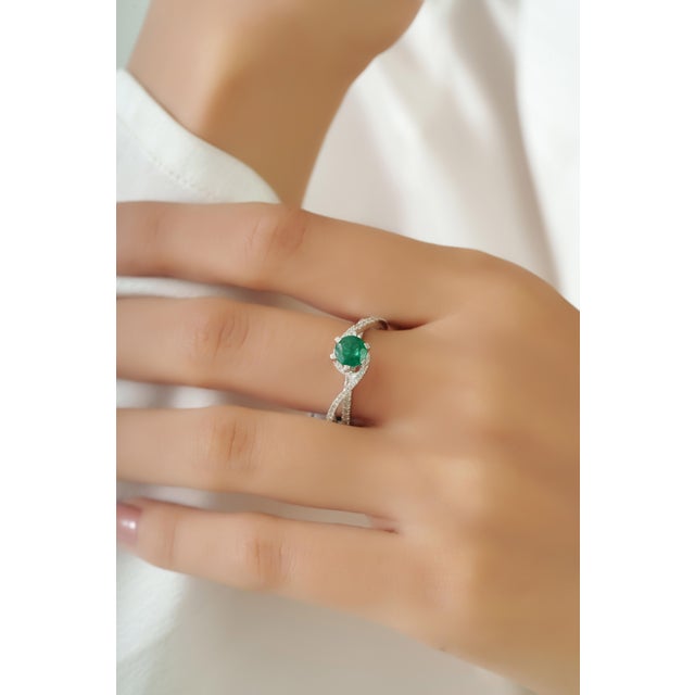 This crossover cocktail ring features a 0.69 carat of emerald set in 18K white gold. The emerald measuring approximately...