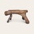 Hand-carved folk art stool in solid wood with a natural live edge seat and sculptural tripod base. One leg is peg-joined...