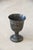 A footed pewter goblet engraved "CLASS OF 84," with banded ring detail below the rim. Warm, aged pewter finish with light...