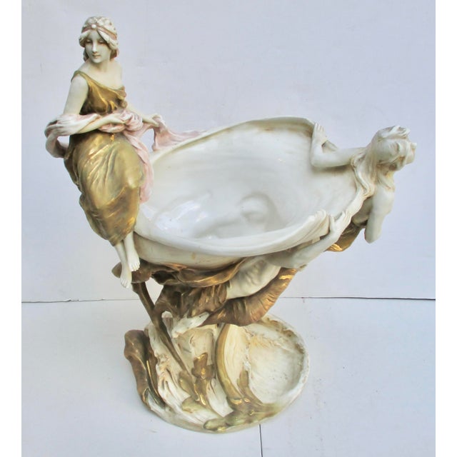 Sea waves, Mermen, and a shell boat push forward in grand form. They carry the beauty of the sea and announce her arrival....