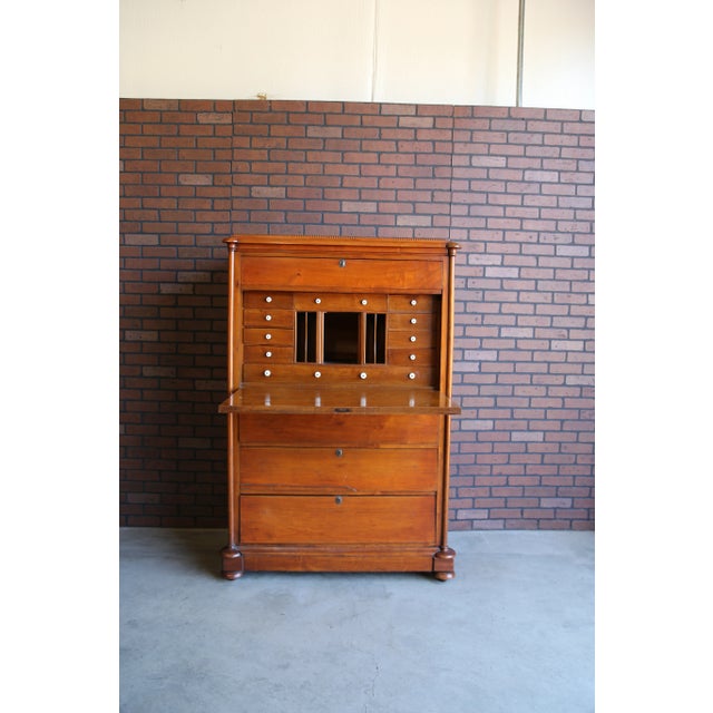 A remarkable Biedermeier style dropleaf secretaire or fall front secretary desk and tall chest of drawers. This piece is...