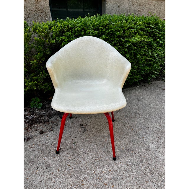 Gorgeous red legs and a swivel seat on this great Eames style chair. An off white or cream color molded fiberglass seat...