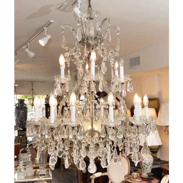 Vintage English Regency style 16-light crystal two-tier chandelier, profusely hung throughout with scalloped pendants.