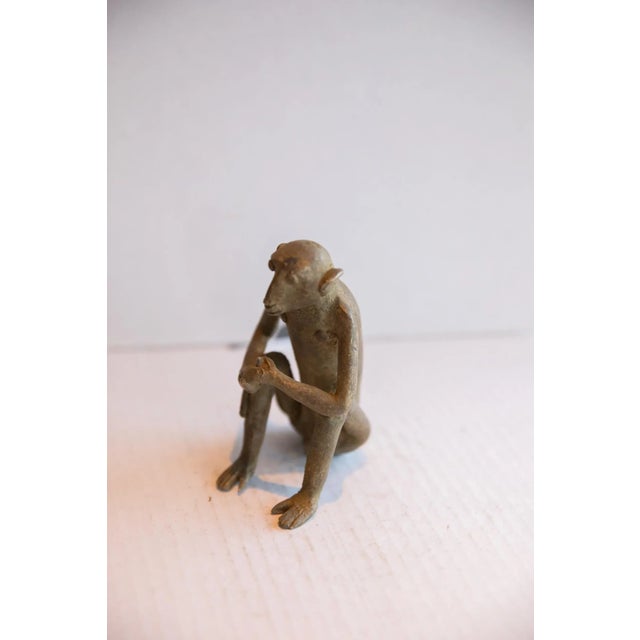 :: Vintage handmade African sitting monkey with banana sculpture. Circa late mid 20th century, though possibly older, this...