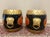 A pair of antique decorative ebonized, gilt and painted hand carved lidded barrels depicting figures in traditional garden...
