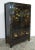 The two panels door of this black Chinese Chinoiserie cabinet is adorn with hand painted flowers and flying butterfly and...