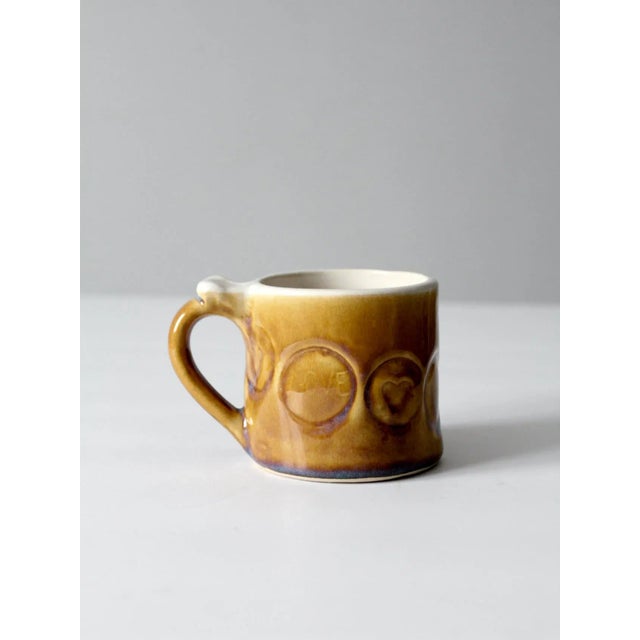 This is a vintage studio pottery mug from Daybreak Pottery. The hand-crafted ceramic mug features stamped circles designs...