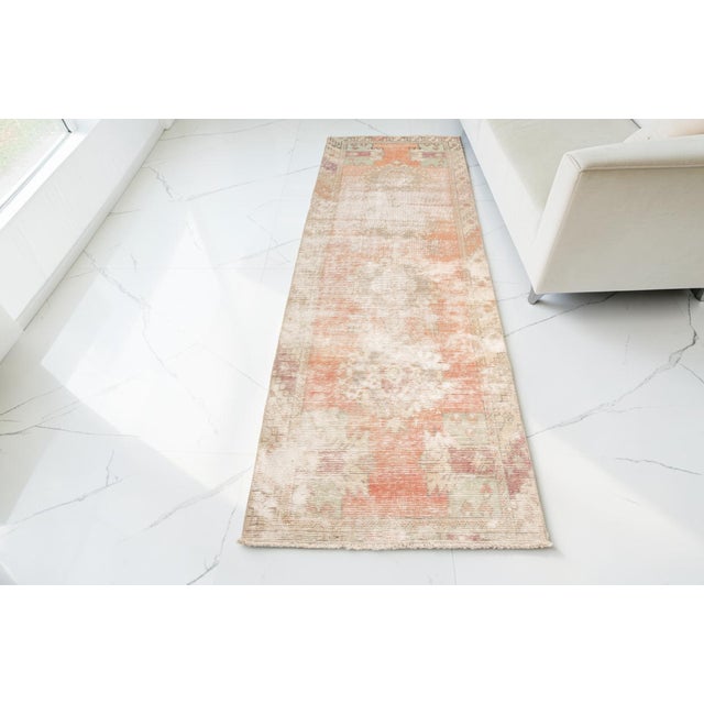 This is a vintage Turkish Oushak rug from the Mid 20th Century. The piece was hand-knotted.