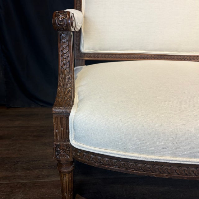 Elegant 19th century French Louis XVI canapé, handcrafted in richly patinated walnut and distinguished by its beautifully...