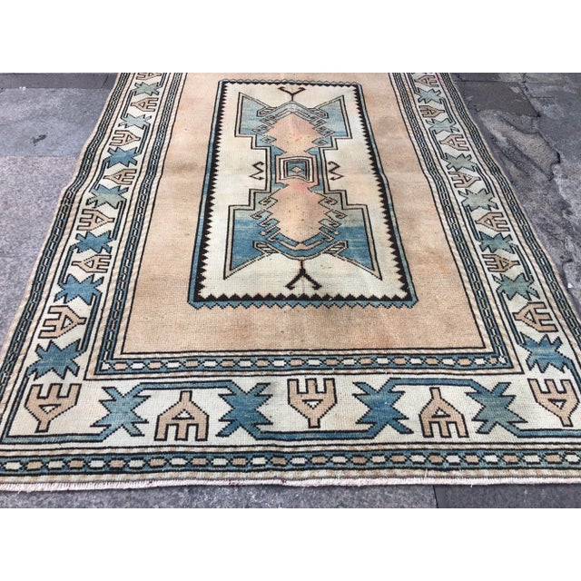 This is a vintage Turkish Oushak rug from the 1960s. The piece was hand-knotted.