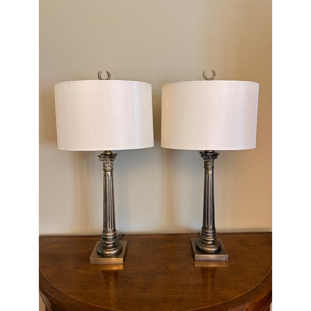 Pair of Neoclassical Brass Lamps Heavy brass Ionic Greek column lamps with laurel wreath finial and oval shades. 29” x 5”...