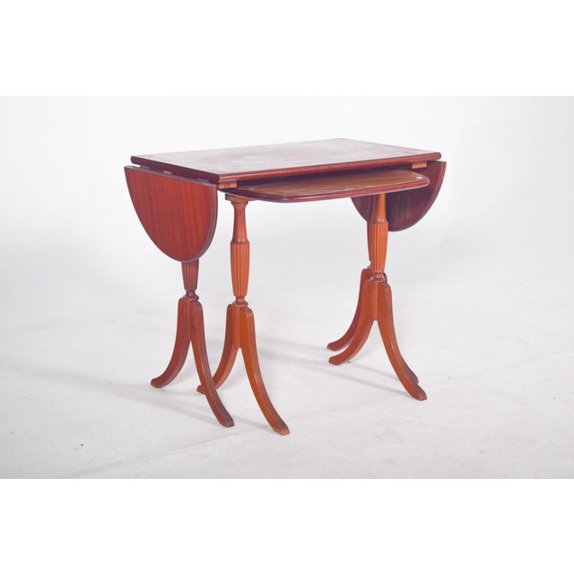 English mother tables. The larger table has an extendable top with semicircular side wings that can be folded or raised as...