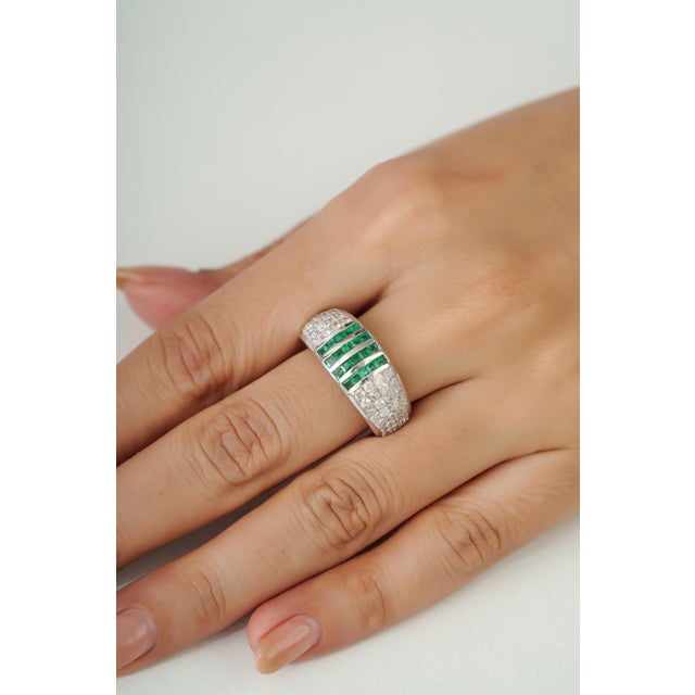 This striking ring is crafted in 925 sterling silver, featuring 0.82 carats of natural emeralds in square cuts measuring...