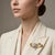 Elevate your accessory collection with this exquisite Floral Ribbon Shape Brooch, crafted from a luxurious blend of 14k...