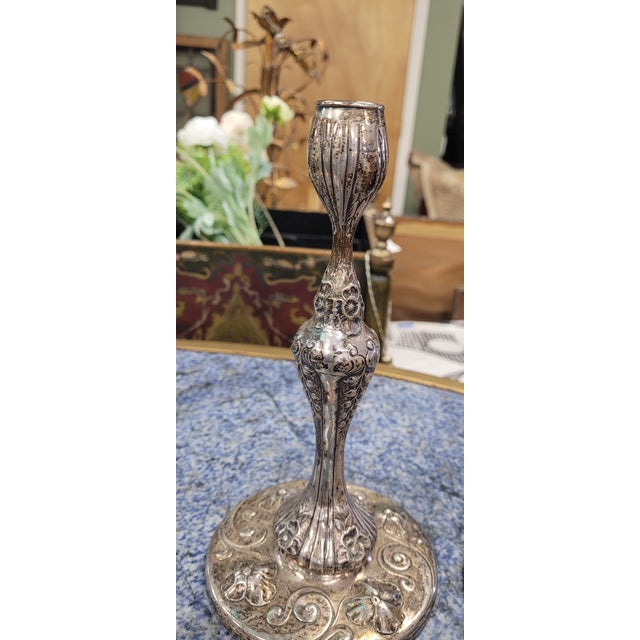 A pair of antique art nouveau sterling silver candlesticks. Each features hand done stylized floral bodies with detachable...