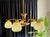 This Art-Deco pendant lamp with 5 glass spheres is truly a feast for the eyes! The elegantly designed chandelier in brass...