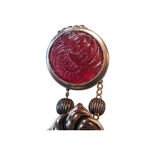 Three-tier charm brooch suspended from fluid chain with an ornate carnelian, snake, and jade cabochon. Please refrain from...