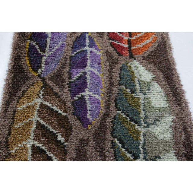 Hand-knotted in lush, high-pile wool in Sweden circa 1960-1970, this 3x6 vintage Swedish Rya runner rug is a bold new...