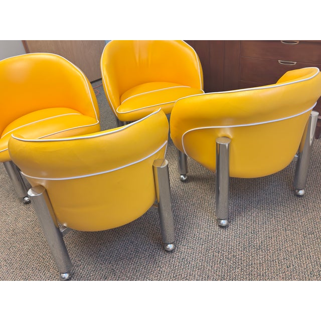 Four Fabulous retro club chairs, yellow vinyl with white piping and chrome tube legs on matching chrome casters in great...