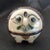 Vintage, owl pottery figurine with floral design in the back signed "R". Dimensions 5"W X5"H X 3"D
