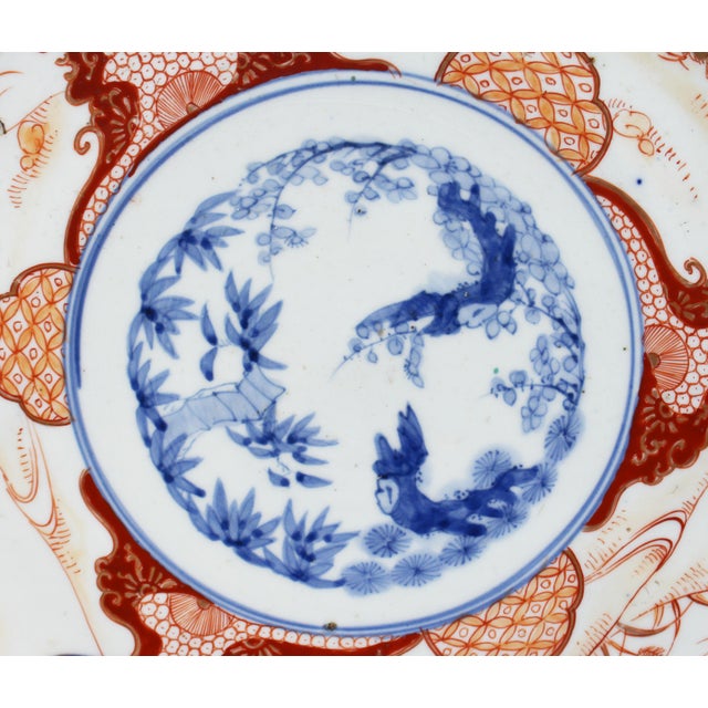Imari charger featuring the three friends of winter: pine, prunus, & bamboo in the central medallion, surrouned by panels...
