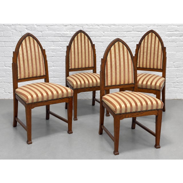 A striking set of four Dutch Art Deco oak dining chairs attributed to the Amsterdam School, circa 1930s. Tall, pointed...