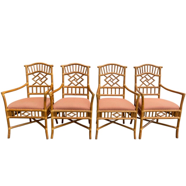 A group of faux bamboo rattan armchairs by Lexington Furniture, featuring geometric fretwork backs and warm honey-toned...