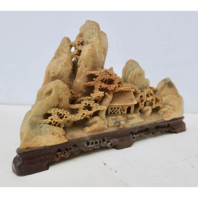 Soapstone miniature mountain range over a mountain village. The intricate little scene of dramatic cliffs over a wooded...