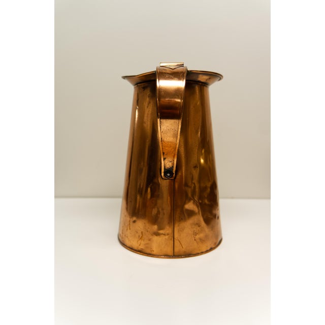 An antique late 18th to early 19th century hammered copper measure or pitcher with an approximate 4-liter capacity....
