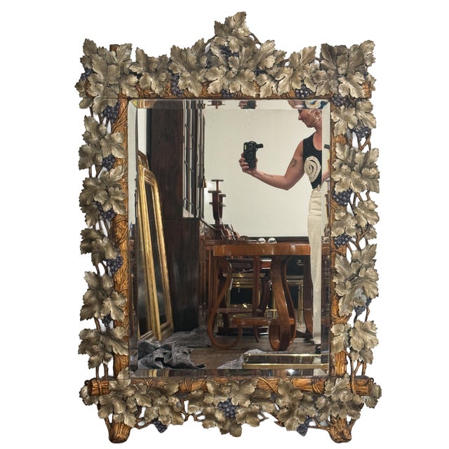 A large Continental rectangular beveled glass mirror with a very ornate grapevine frame of hand-carved wood - in the Black...