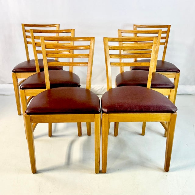 This is a set of 6 Art Deco honey maple dining chairs with burgundy vinyl seats. The upholstery is newer than the...