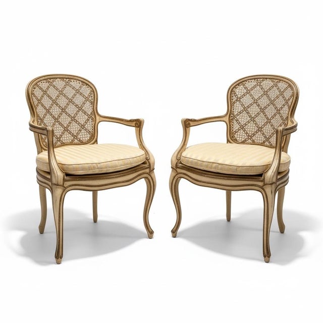 This is a lovely pair of 1950s ivory and gilt painted French bergere chairs. They are in very good condition with some age...